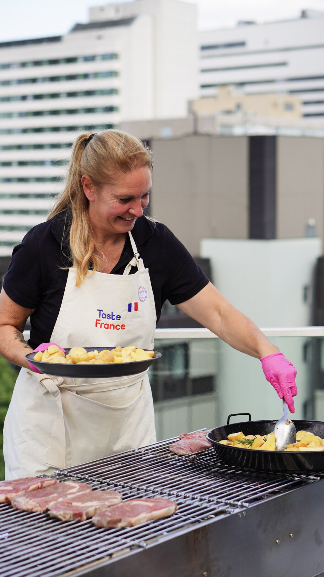 person in Kochschürze am grill unter freiem Himmel