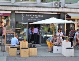 Menschen vor dem Saint Charles Pop auf Sitzmobiliar